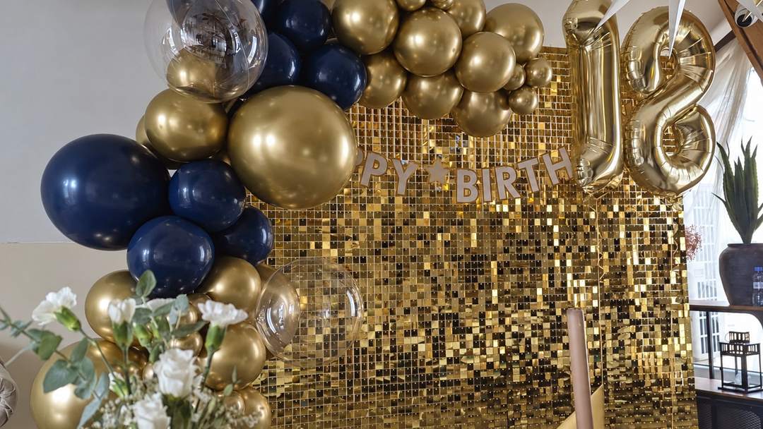 Złota ścianka cekinowa z girlandą z balonów granatowych i złotych oraz cyframi 18 — dekoracja juppi w Cafe Family w Poznaniu