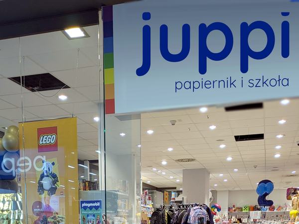 Szyld juppi — papiernik i szkoła — nad wejściem, obok baner LEGO
